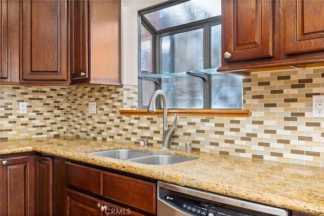 kitchen featuring dishwasher, light stone countertops, sink, and tasteful backsplash