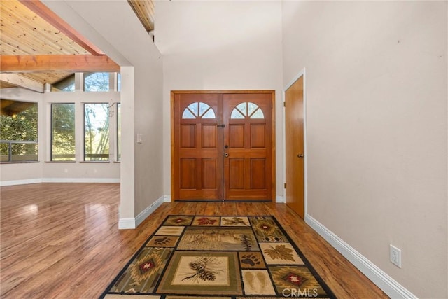 entrance foyer with hardwood / wood-style flooring, beam ceiling, and high vaulted ceiling