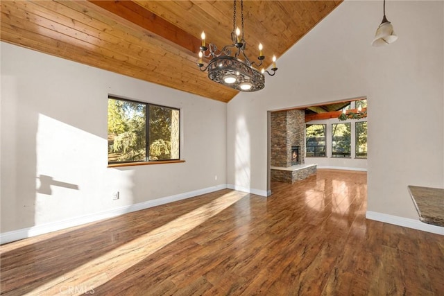 unfurnished living room with hardwood / wood-style flooring, plenty of natural light, a fireplace, and high vaulted ceiling