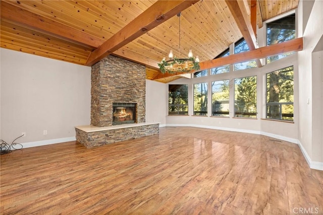 unfurnished living room with wood ceiling, an inviting chandelier, beamed ceiling, a fireplace, and hardwood / wood-style floors