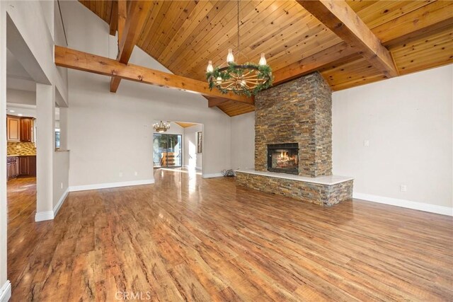 unfurnished living room with wood ceiling, a stone fireplace, high vaulted ceiling, and wood-type flooring