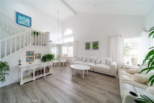 living room featuring high vaulted ceiling, plenty of natural light, hardwood / wood-style flooring, and beam ceiling