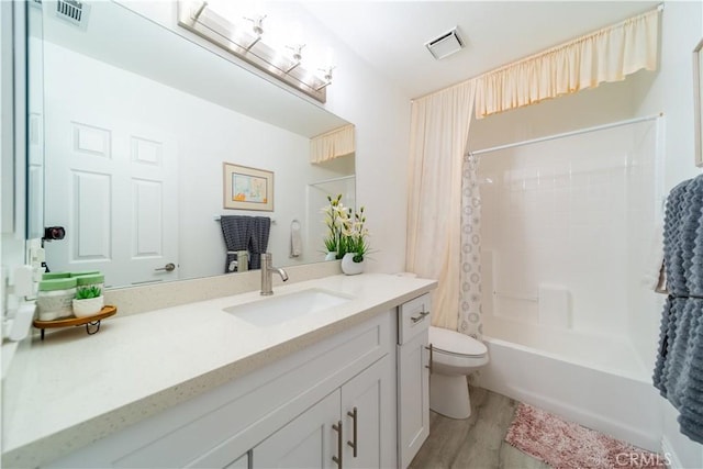 full bathroom with wood-type flooring, toilet, vanity, and shower / tub combo