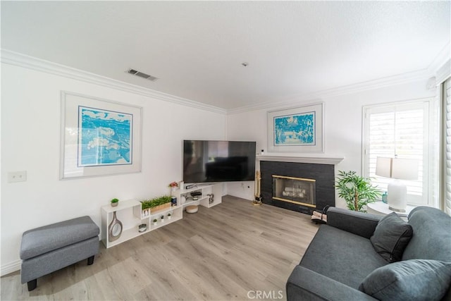 living room with crown molding and light hardwood / wood-style floors