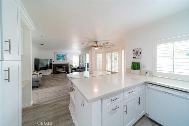 kitchen with ceiling fan, white cabinetry, dishwasher, and kitchen peninsula