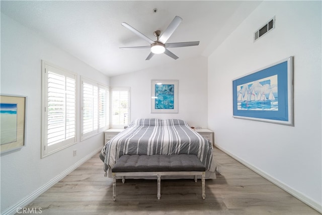 bedroom with ceiling fan, light wood-type flooring, and vaulted ceiling