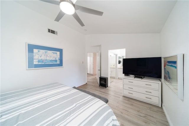 bedroom with vaulted ceiling, ceiling fan, ensuite bathroom, and light hardwood / wood-style flooring