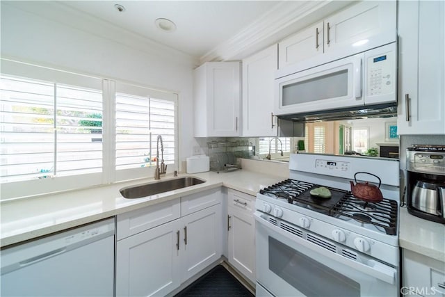 kitchen featuring white appliances, white cabinets, decorative backsplash, sink, and crown molding