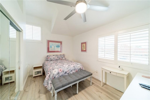 bedroom with ceiling fan, multiple windows, and light wood-type flooring