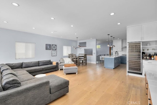 living room featuring light wood-type flooring and a notable chandelier