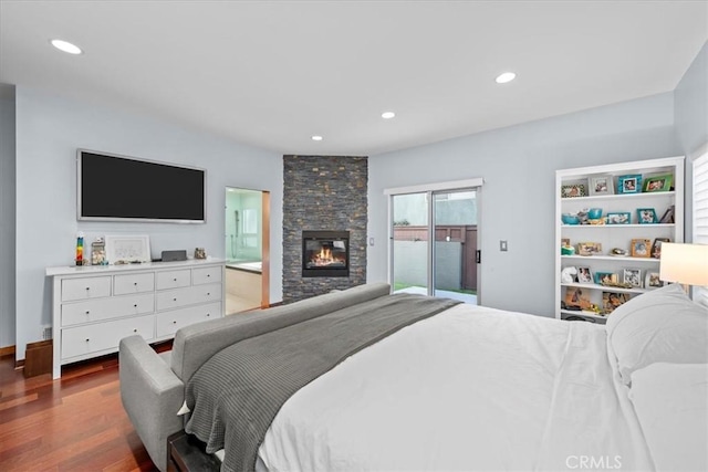 bedroom with access to outside, ensuite bathroom, a fireplace, and hardwood / wood-style flooring