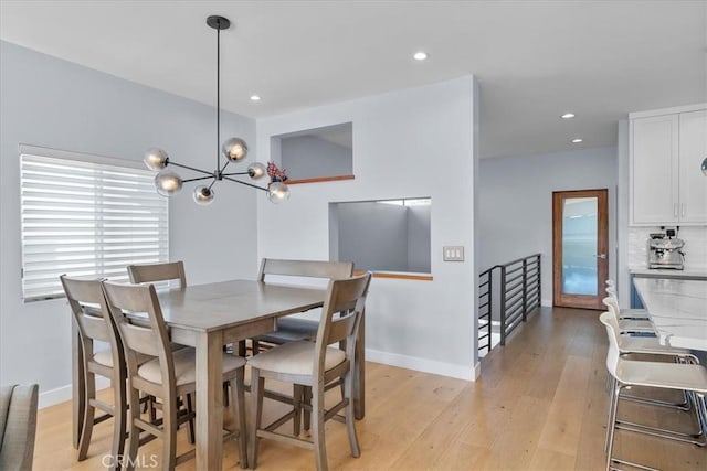 dining room with light hardwood / wood-style flooring and a notable chandelier