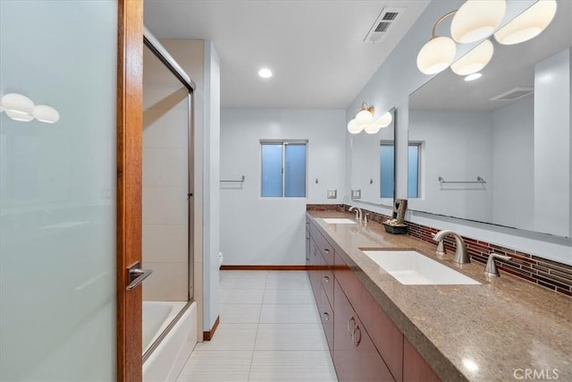 full bathroom with vanity, bath / shower combo with glass door, tile patterned flooring, decorative backsplash, and toilet