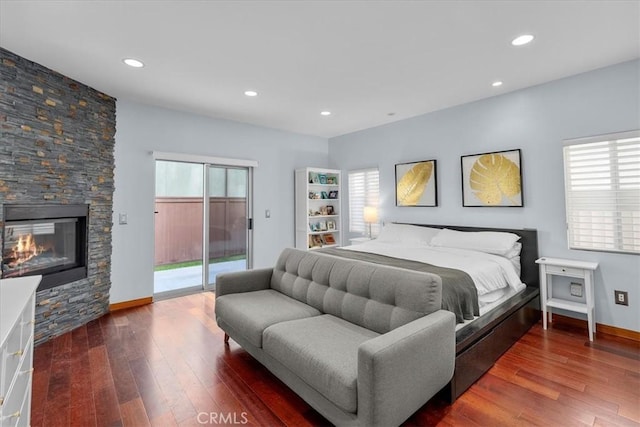 bedroom with access to outside, multiple windows, and wood-type flooring