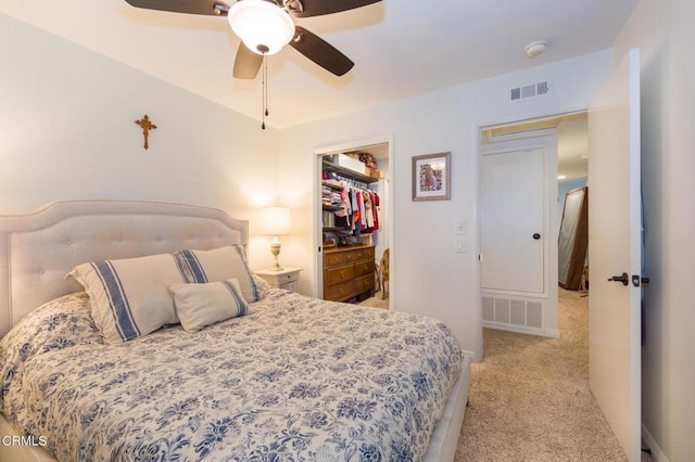 bedroom with light carpet, a spacious closet, a closet, and ceiling fan