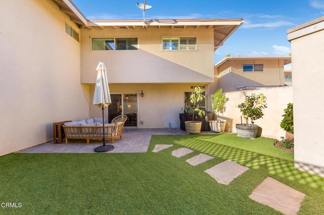 back of property featuring a lawn, outdoor lounge area, and a patio