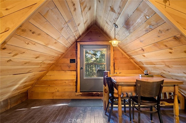 interior space with dark hardwood / wood-style floors, lofted ceiling, and wood walls