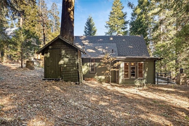 rear view of house with a storage shed