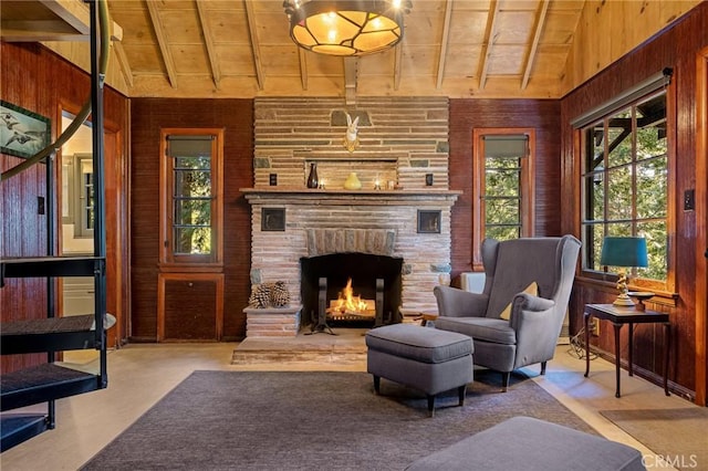 sitting room with a fireplace, vaulted ceiling, wooden walls, and wood ceiling