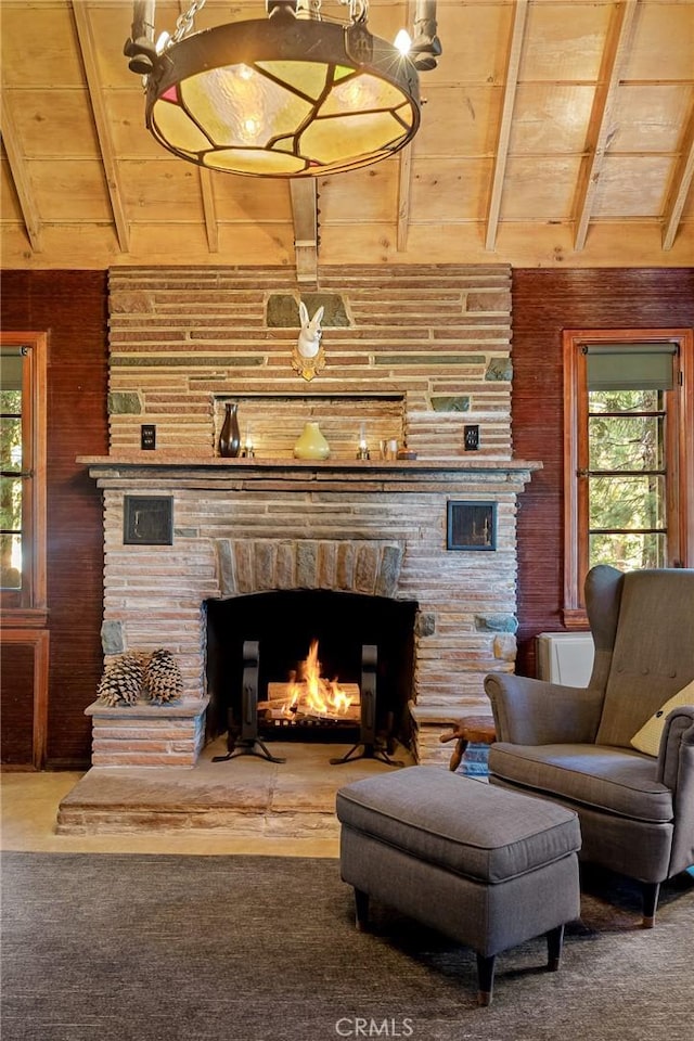 living room featuring wood walls, vaulted ceiling with beams, a healthy amount of sunlight, and wood ceiling