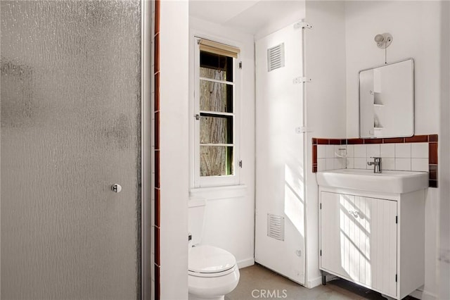 bathroom featuring tasteful backsplash, sink, walk in shower, and toilet