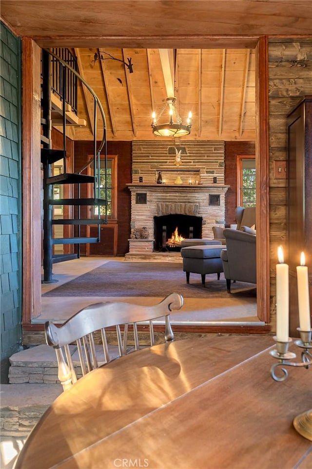 living room with lofted ceiling with beams, wooden ceiling, and a fireplace