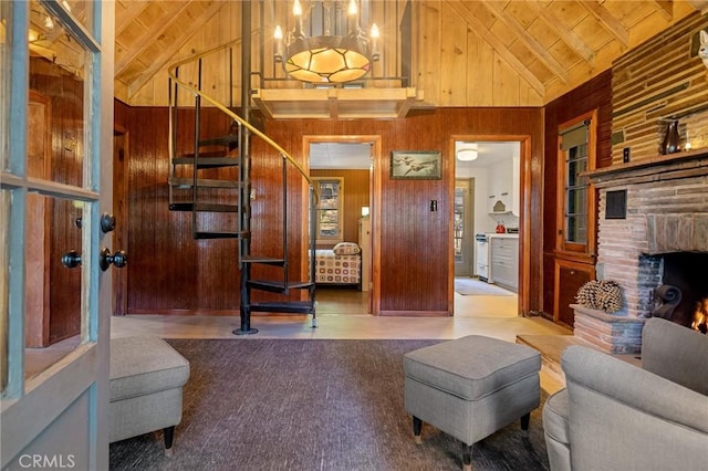 living room featuring a fireplace, high vaulted ceiling, wooden walls, and wood ceiling