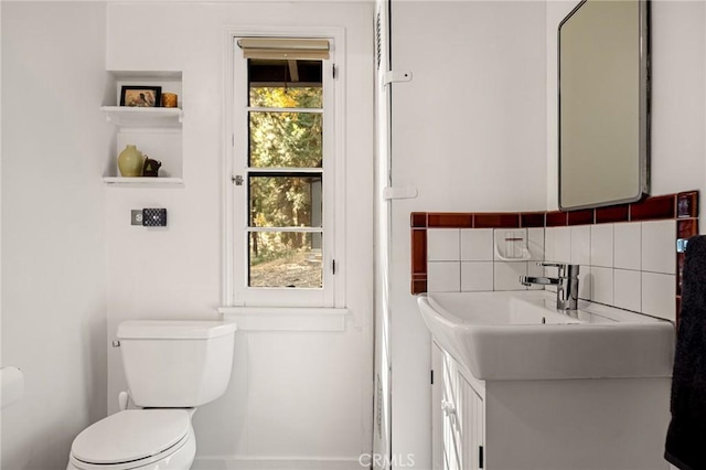 bathroom with decorative backsplash, vanity, toilet, and a healthy amount of sunlight