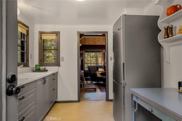 kitchen featuring a wealth of natural light, gray cabinets, sink, and stainless steel refrigerator