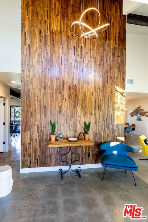 interior space featuring a notable chandelier and wood walls