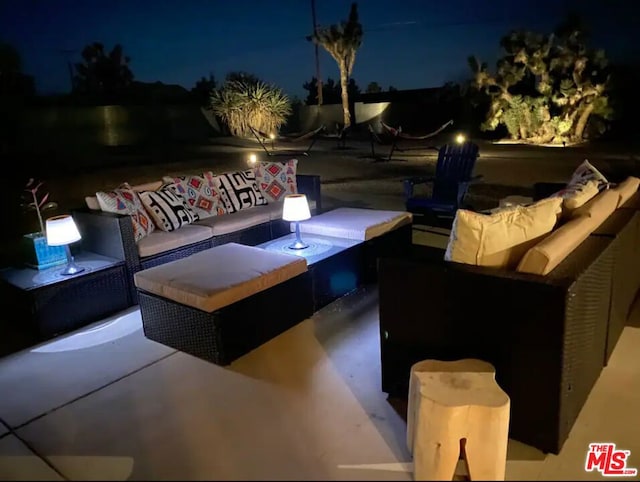 patio at night featuring an outdoor living space