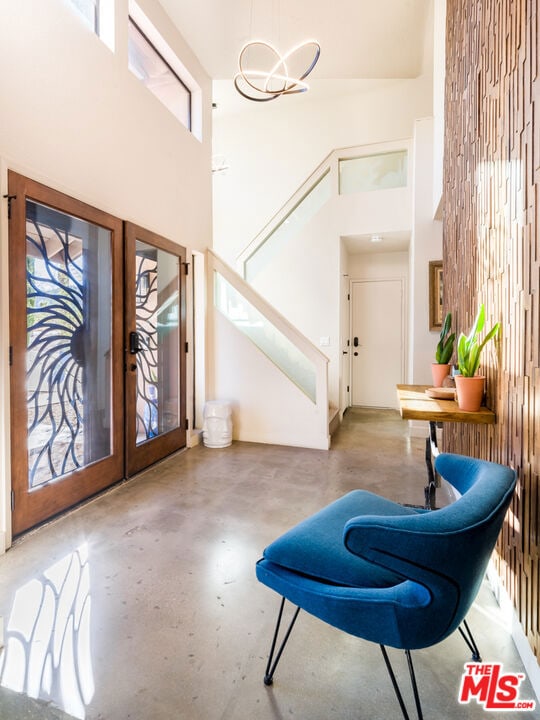 entryway with french doors, a high ceiling, and a notable chandelier