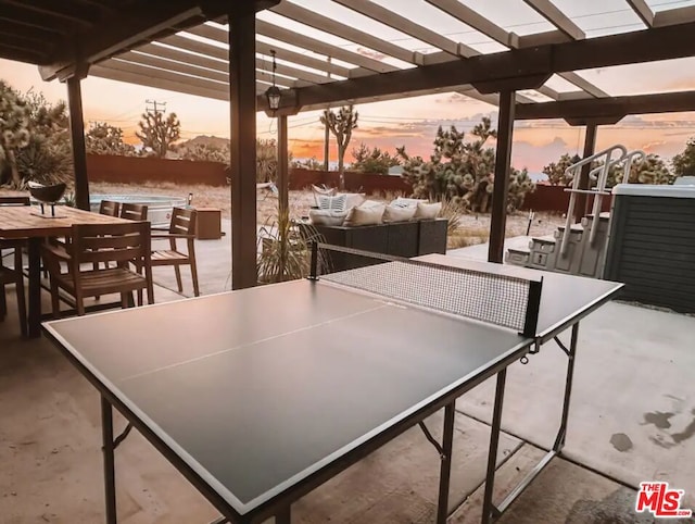 patio terrace at dusk featuring a pergola and an outdoor living space