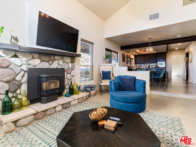 living room with beam ceiling, a wood stove, and high vaulted ceiling