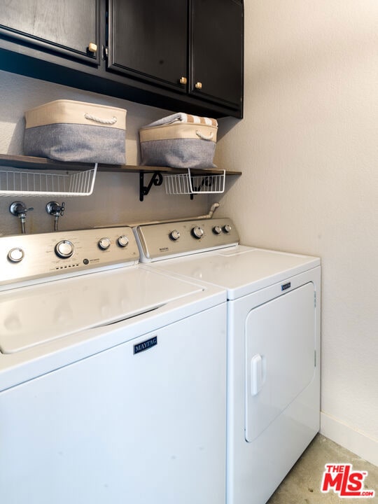 laundry room featuring washing machine and dryer and cabinets