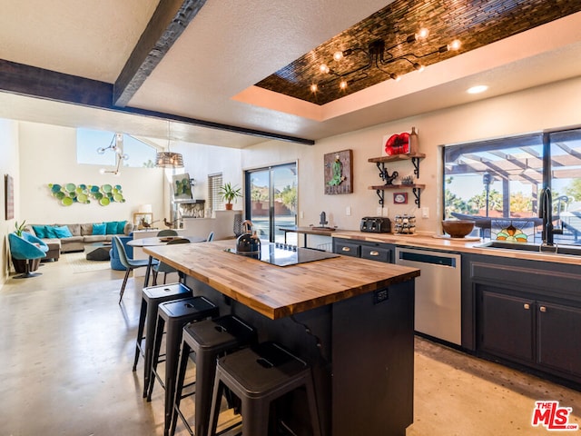 kitchen with butcher block countertops, dishwasher, sink, and a breakfast bar area