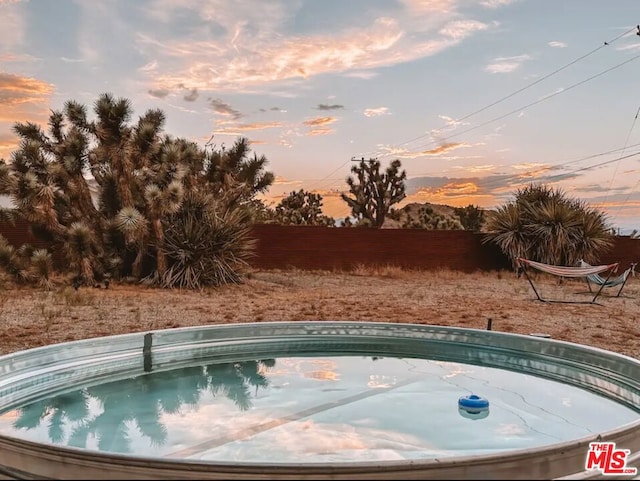 view of pool at dusk