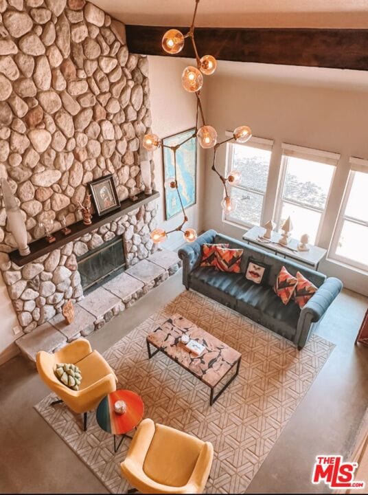 unfurnished living room featuring beam ceiling and a fireplace