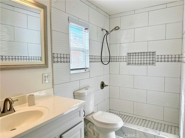 bathroom featuring toilet, vanity, and tiled shower