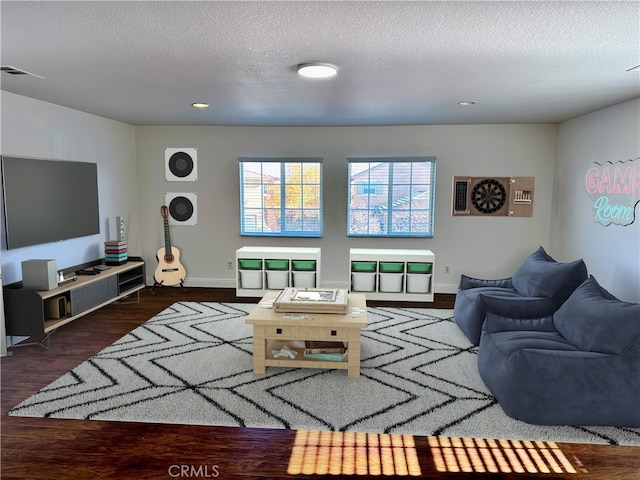 living room with dark wood-type flooring and a textured ceiling