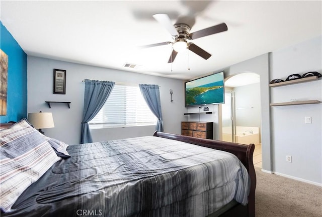 carpeted bedroom with ensuite bathroom and ceiling fan