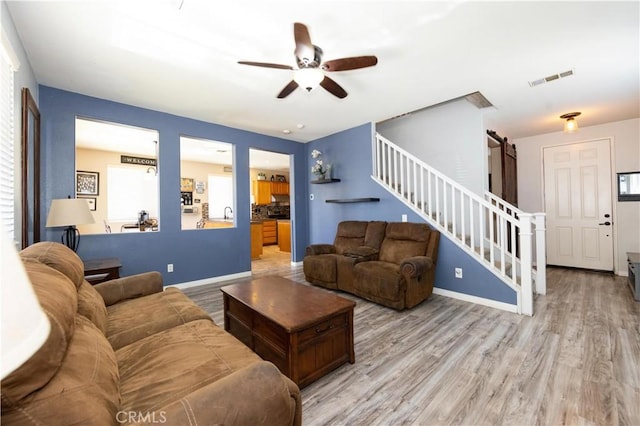 living room featuring ceiling fan and light hardwood / wood-style floors