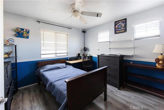 bedroom with multiple windows, ceiling fan, and hardwood / wood-style flooring