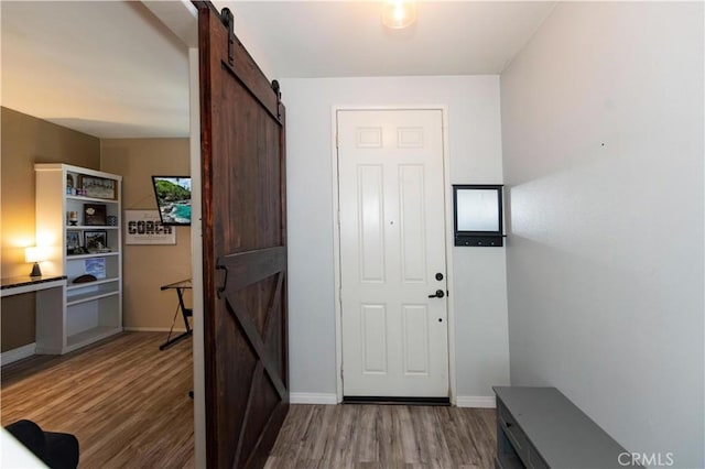 doorway to outside with a barn door and hardwood / wood-style flooring