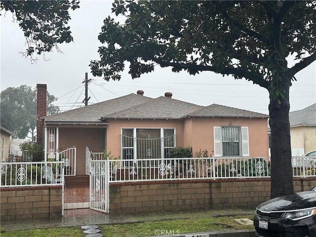 311 S Pickering Way, Montebello, CA 90640 - view of front facade with a fenced front yard, a shingled roof, stucco siding, and a gate
