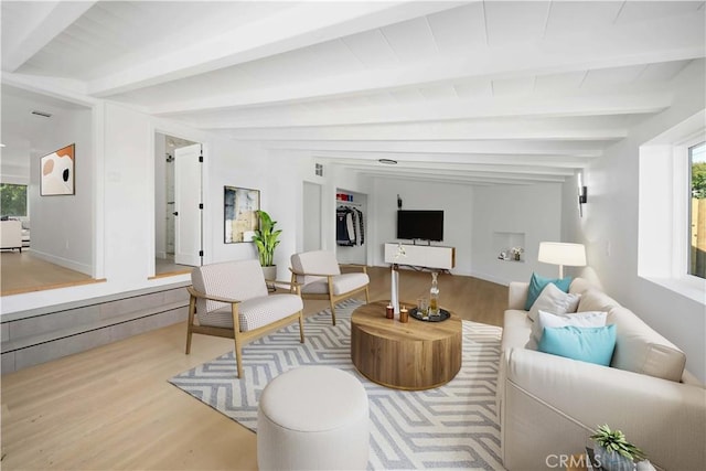 living room with lofted ceiling with beams and light hardwood / wood-style floors