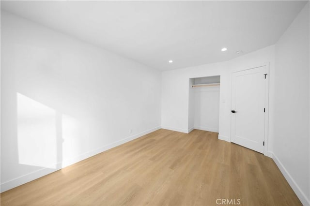 unfurnished bedroom with light hardwood / wood-style floors and a closet