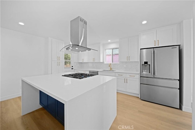 kitchen featuring a center island, light hardwood / wood-style floors, island range hood, white cabinetry, and stainless steel appliances