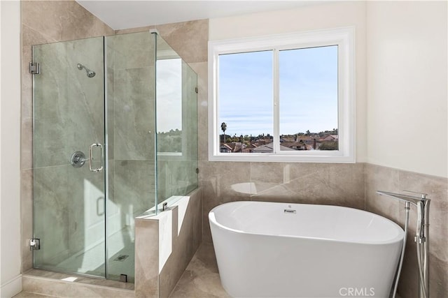 bathroom with tile patterned flooring, plus walk in shower, and tile walls