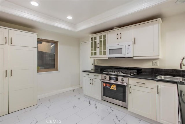 kitchen with appliances with stainless steel finishes, white cabinets, a raised ceiling, and sink